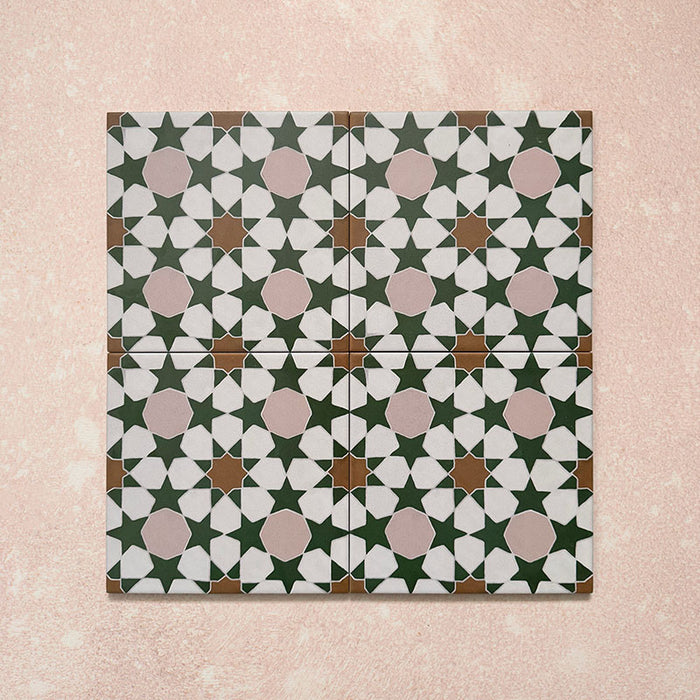 Disposición de cuatro azulejos de estilo marroquí Agraba Tanane 20x20 cm con patrón geométrico de estrellas y cruces en verde profundo, rosa empolvado, blanco y tonos tierra, con acabado mate suave.