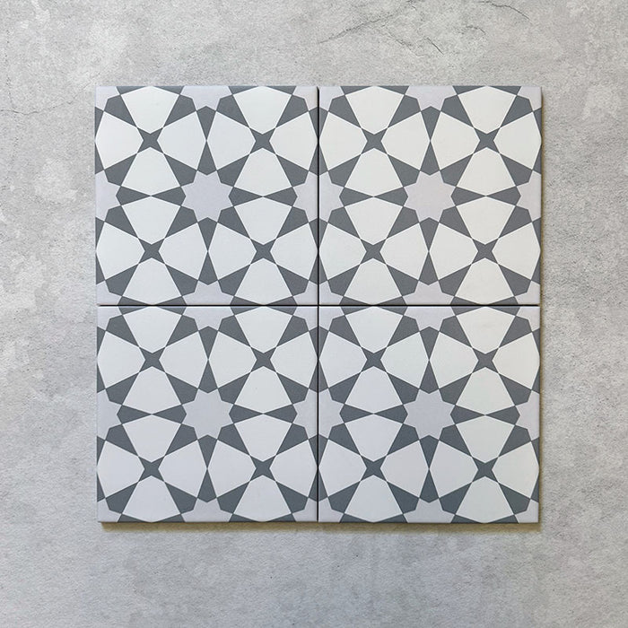 Presentación agrupada de azulejos cerámicos mate de estilo marroquí Agraba Plateado 20x20 cm, con patrón geométrico repetido en plateado y blanco inspirado en el diseño tradicional morisco, aptos para uso en interior y exterior en paredes y suelos.