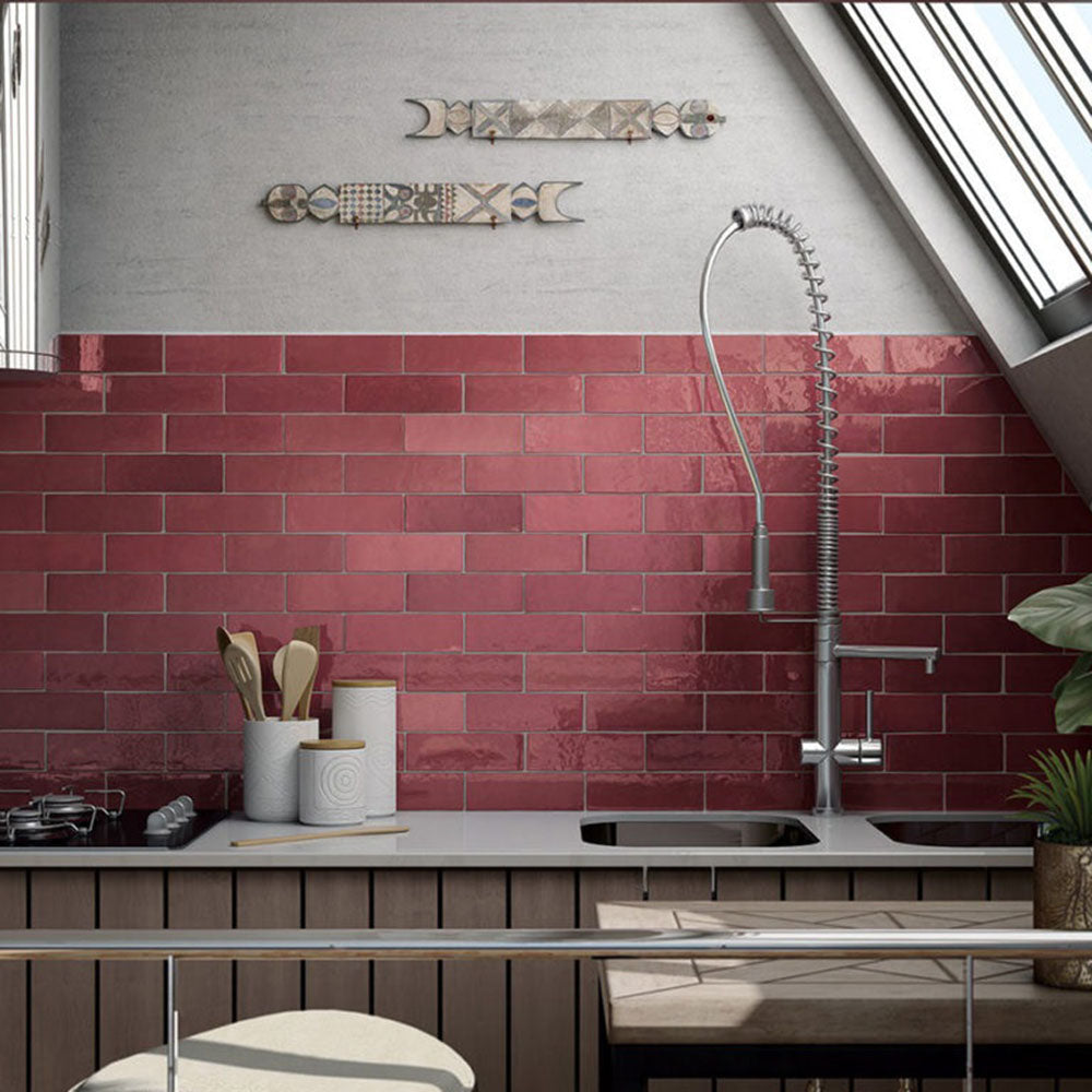 Interior de cocina con azulejos de pared cerámicos Zellij Burdeos Ladrillo 6,5 × 20 cm de estilo marroquí en tonos rojos intensos, colocados en un diseño tipo ladrillo con acabado brillante, combinados con fregadero moderno, grifería cromada y accesorios de cocina contemporáneos.