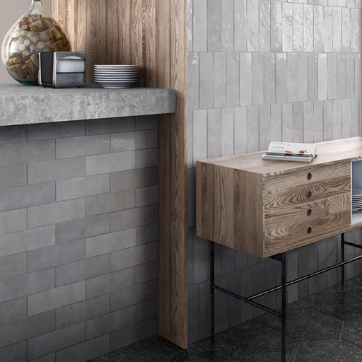 Interior de cocina con azulejos de pared cerámicos Zellij Gris Ladrillo 6,5 × 20 cm de estilo marroquí, colocados en un diseño tipo ladrillo con suave variación en tonos grises y acabado brillante, combinados con mobiliario de madera, encimeras de hormigón y suelos oscuros.