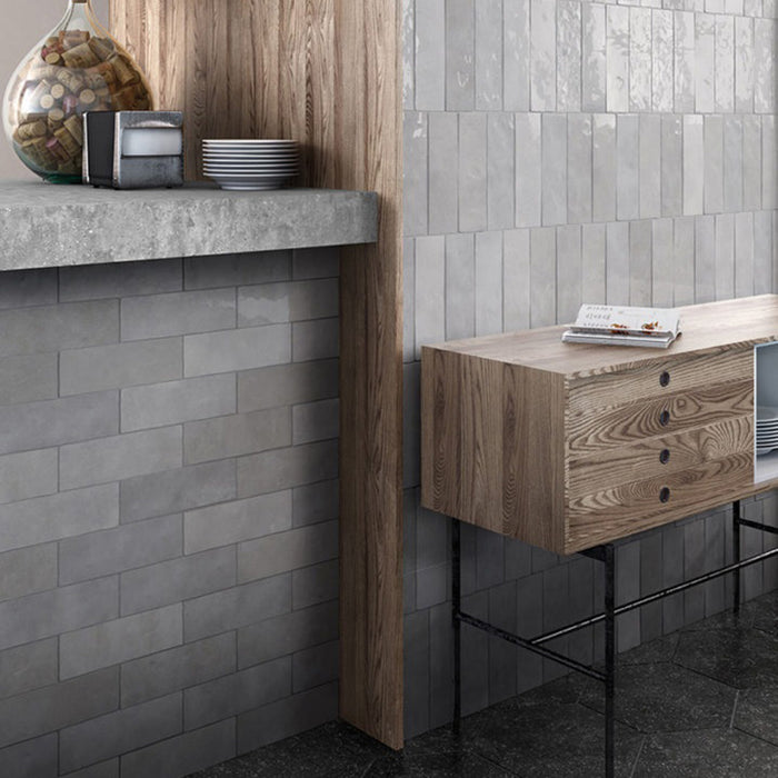 Interior de cocina con azulejos de pared cerámicos Zellij Gris Ladrillo 6,5 × 20 cm de estilo marroquí, colocados en un diseño tipo ladrillo con suave variación en tonos grises y acabado brillante, combinados con mobiliario de madera, encimeras de hormigón y suelos oscuros.