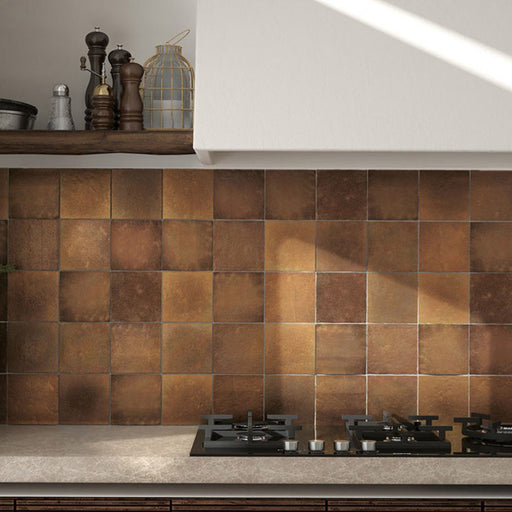 Interior de cocina con azulejos de pared cerámicos Zellij Dorado Cuadrado 13,2 × 13,2 cm de estilo marroquí, formando un salpicadero cálido y tonal con rica variación en tonos dorados, acabado brillante de aspecto artesanal y una sutil textura superficial, combinados con madera natural y piedra para aportar profundidad y contraste.