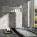 Interior de baño con azulejos de pared cerámicos Zellij Blanco Cuadrado 13,2 × 13,2 cm de estilo marroquí, colocados en un diseño en cuadrícula, con sutil variación tonal y efecto artesanal, combinado con bañera integrada, estante empotrado y luz natural.