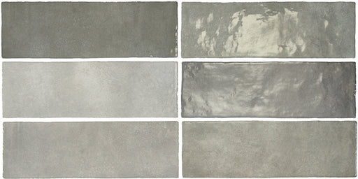 Vista cenital de azulejos de pared cerámicos Zellij Gris Ladrillo 6,5 × 20 cm de estilo marroquí, dispuestos en un patrón desplazado, mostrando una suave variación tonal en gris, un acabado brillante de aspecto artesanal y bordes ligeramente irregulares.