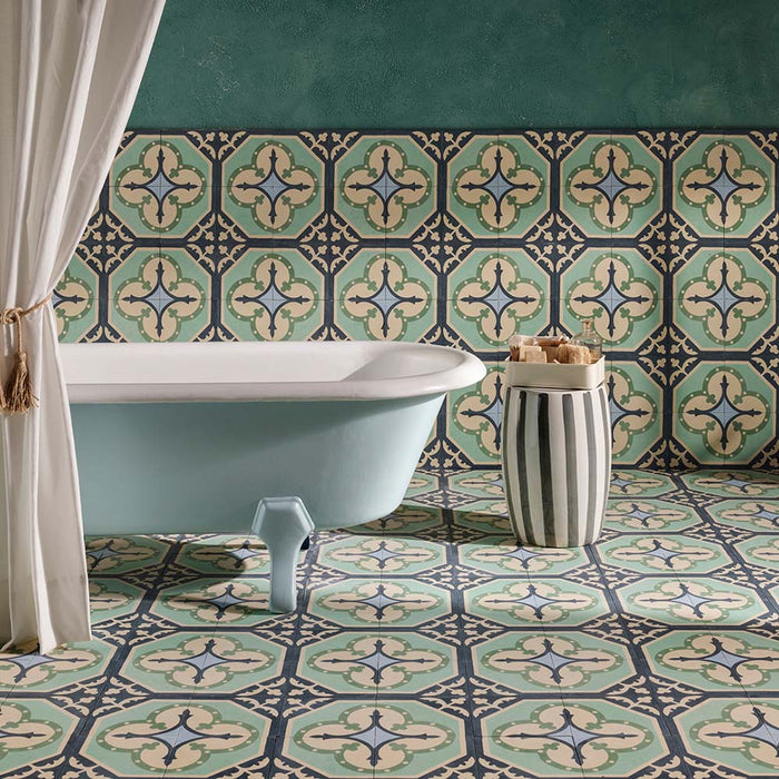 Interior de baño con baldosas Europa Gothenberg 20 × 20 cm de estilo Victoriano Marroquí en tonos azul, verde menta y crema, instaladas tanto en suelo como en pared, combinadas con una bañera exenta y una pared de acento en verde.