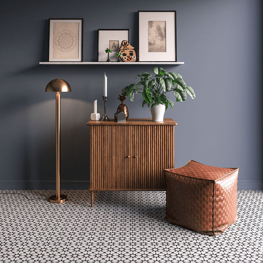 Espacio interior con azulejos cerámicos de estilo marroquí Agraba Mini Blanco y Negro 15x15 cm para suelo, mostrando un clásico patrón geométrico en blanco y negro, combinados con mobiliario de estilo mid-century y paredes en gris suave.