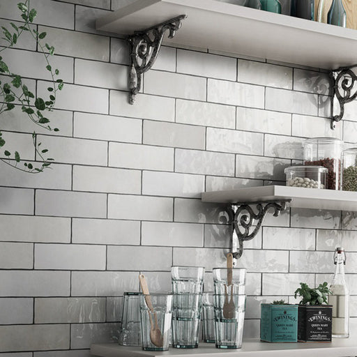 Interior de cocina con azulejos de pared Zellij Blanco Ladrillo 6,5 × 20 cm de estilo marroquí, colocados en un diseño tipo ladrillo clásico, con acabado brillante y sutil variación tonal, combinados con estanterías abiertas, cristalería y accesorios decorativos.