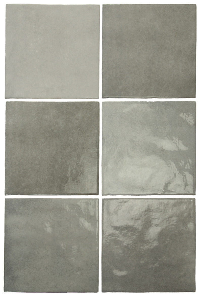 Vista cenital de azulejos de pared cerámicos Zellij Gris Cuadrado 13,2 × 13,2 cm de estilo marroquí, dispuestos para destacar la suave variación tonal en gris, el acabado brillante de aspecto artesanal y los bordes sutilmente irregulares para un aspecto auténtico y lleno de carácter.
