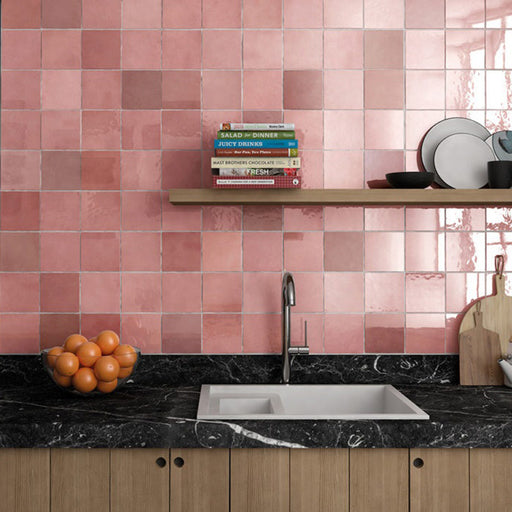 Interior de baño con azulejos de pared cerámicos Zellij Rosa Ladrillo 6,5 × 20 cm de estilo marroquí en tonos rosa suaves, colocados en un diseño tipo ladrillo con acabado brillante, combinados con lavabo blanco, estanterías oscuras y accesorios modernos para un acabado cálido y contemporáneo.