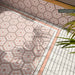 Zona exterior revestida con azulejos Atlas Pink Mini Brick Matt de 5 × 15 cm, utilizados como un delicado borde rosa alrededor de azulejos hexagonales decorados de estilo marroquí, creando un diseño de suelo decorativo y armonioso.