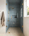 Baño con azulejos de pared Atlas Blue Mini Brick 5x15 cm en acabado brillo, instalados en disposición vertical en las paredes de la ducha y en nichos integrados, mostrando tonos azules intensos con una sutil variación tonal, combinados con grifería en latón y un suelo en espiga en tonos claros para un acabado refinado.