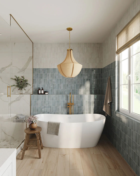 Baño con azulejos de pared Atlas Blue Mini Brick 5x15 cm en acabado brillo, instalados en disposición vertical a media altura, mostrando tonos azules intensos con sutil variación tonal, combinados con una bañera exenta, grifería en latón y suelo de madera cálida.