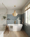 Baño con azulejos de pared Atlas Blue Mini Brick 5x15 cm en acabado brillo, instalados en disposición vertical a media altura, mostrando tonos azules intensos con sutil variación tonal, combinados con una bañera exenta, grifería en latón y suelo de madera cálida.
