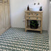 Baño con azulejos de estilo marroquí Agraba Verde 20x20 cm para suelo en verde y blanco, combinados con mueble de madera rústica, paredes paneladas blancas y grifería moderna en latón para un ambiente natural de inspiración artesanal.