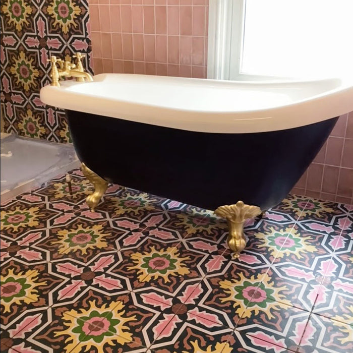 Baño con baldosas cerámicas de estilo marroquí Cabana Havana 20x20 cm en suelo y pared, combinado con bañera exenta negra con patas y grifería dorada.