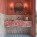 Azulejos de pared Beijing Rose Pink Brick de 5,1 × 16,1 cm de estilo marroquí, con suaves variaciones de tonos rosa en un baño de ambiente cálido con paredes en color coral, un lavabo de mármol rosa y azulejos decorados en el suelo.
