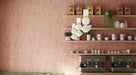 Interior de café con azulejos de pared Atlas Pink Mini Brick 5x15 cm en acabado mate, colocados en disposición vertical tipo ladrillo para enfatizar la altura y crear un fondo suave y rítmico. El tono rosa apagado aporta calidez sin recargar el espacio, mientras que el acabado mate mantiene un aspecto refinado y discreto.