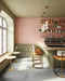 Interior de café con azulejos de pared Atlas Pink Mini Brick 5x15 cm en acabado mate, colocados en disposición vertical tipo ladrillo para enfatizar la altura y crear un fondo suave y rítmico. El tono rosa apagado aporta calidez sin recargar el espacio, mientras que el acabado mate mantiene un aspecto refinado y discreto.