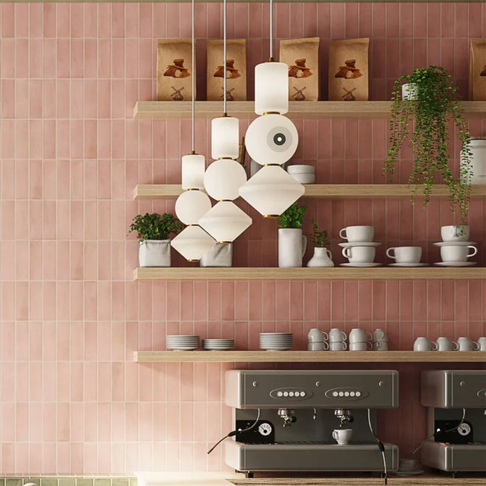 Interior de café con azulejos de pared Atlas Pink Mini Brick 5x15 cm en acabado mate, colocados en disposición vertical tipo ladrillo para enfatizar la altura y crear un fondo suave y rítmico. El tono rosa apagado aporta calidez sin recargar el espacio, mientras que el acabado mate mantiene un aspecto refinado y discreto.