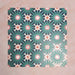 Arrangement of Fizaan Festive Blue 20x20cm Moroccan-style porcelain tiles showcasing a repeating geometric pattern in rich blue, green and soft neutral tones.