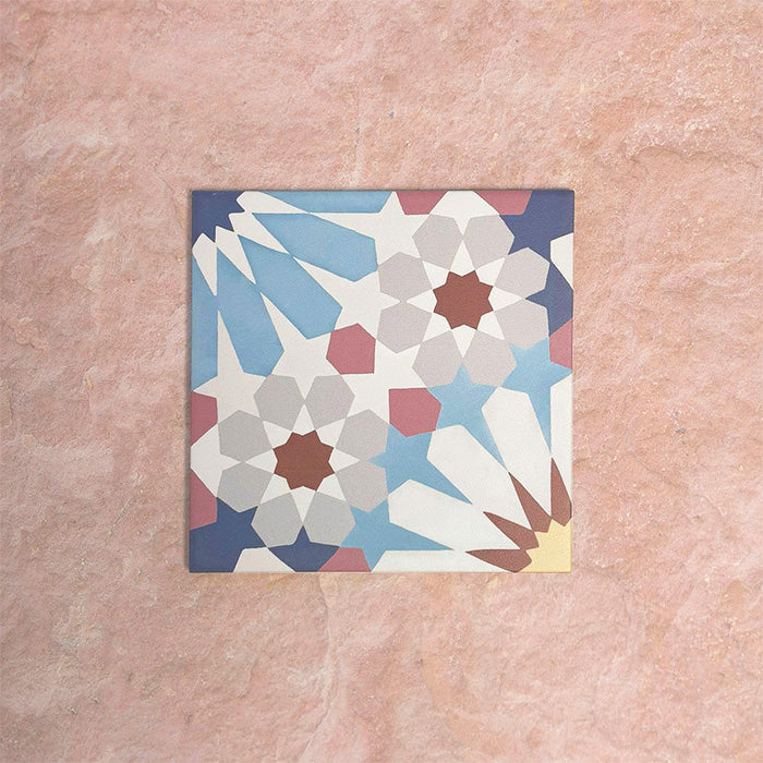 Single Fizaan Fiera 20x20cm Moroccan-style porcelain tile featuring a bold geometric pattern in soft blue, red and neutral tones.