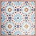 Arrangement of Fizaan Fiera 20x20cm Moroccan-style porcelain tiles, showcasing a repeating geometric pattern in soft blue, red and neutral tones.