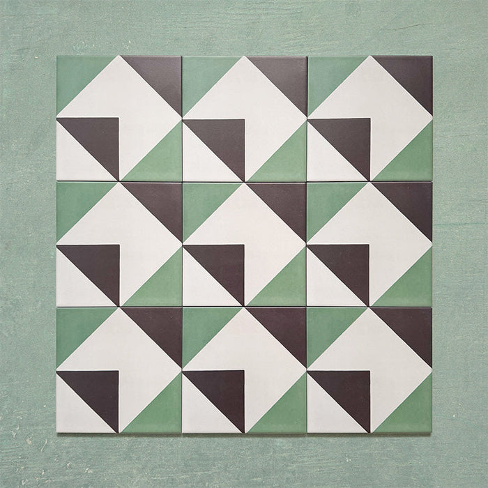 Group layout of Geometry Angles Patterned Tiles in 20cm x 20cm, arranged in a repeating geometric pattern featuring green, white, and black triangular shapes forming interlocking diamond motifs, displayed on a textured green background.