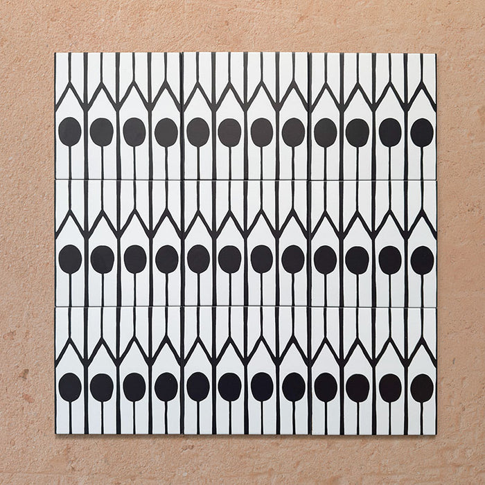 Disposición agrupada de azulejos de estilo marroquí Alhambra Felisa 20x20 cm, mostrando un llamativo patrón vertical en blanco y negro con marcados motivos circulares y arcos apuntados para un diseño distintivo de inspiración marroquí.