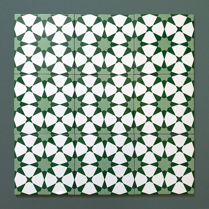 Conjunto de azulejos cerámicos de estilo marroquí Agraba Verde 20x20 cm mostrando un patrón geométrico de estrellas repetido en verdes intensos y blanco, presentados sobre fondo verde oscuro para resaltar el diseño detallado.