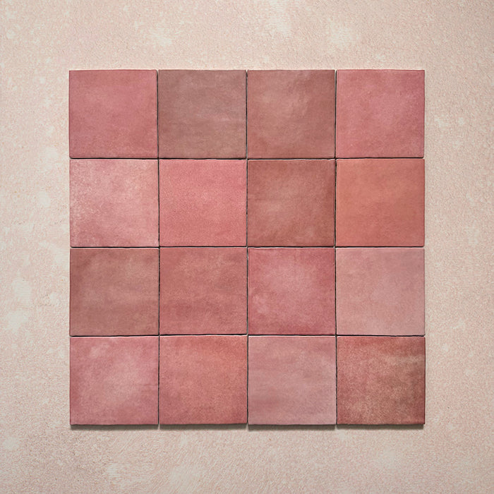 Vista cenital de azulejos de pared cerámicos Zellij Rosa Ladrillo 6,5 × 20 cm de estilo marroquí, dispuestos en cuadrícula, mostrando una suave variación tonal, bordes ligeramente irregulares y un acabado brillante con efecto artesanal en tonos rosados sobre un fondo texturizado.