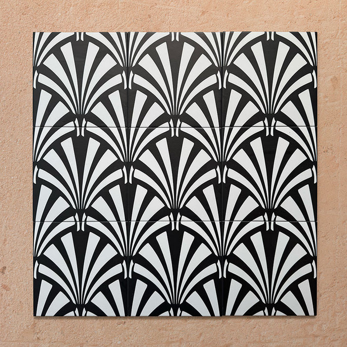 Conjunto de azulejos de estilo marroquí Alhambra Casa 20x20 cm en disposición agrupada, mostrando su llamativo diseño Art Déco en blanco y negro con forma de abanico sobre fondo neutro cálido, ideal para paredes protagonistas o suelos decorativos.