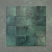 Vista cenital de azulejos de pared cerámicos Zellij Verde Musgo Cuadrado 13,2 × 13,2 cm de estilo marroquí, dispuestos en cuadrícula para destacar la variación tonal en verde, el acabado brillante de aspecto artesanal y los bordes suavemente irregulares.