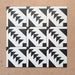 Disposición agrupada de azulejos de estilo marroquí Alhambra Alkazar 20x20 cm, mostrando un audaz patrón geométrico triangular en blanco y negro sobre fondo terracota cálido.