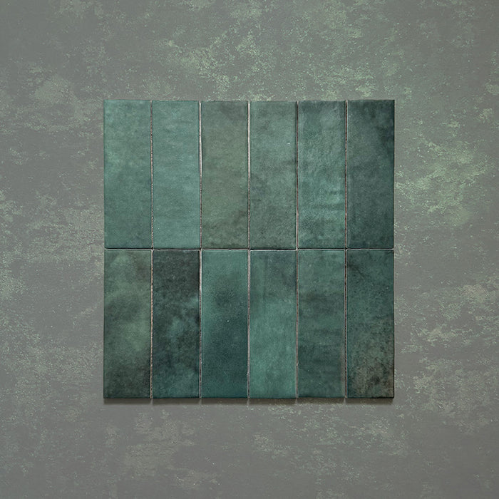 Vista cenital de azulejos de pared cerámicos Zellij Verde Musgo Ladrillo 6,5 × 20 cm de estilo marroquí, mostrando tonos verdes profundos con variación natural, acabado brillante artesanal y bordes ligeramente irregulares para un aspecto auténtico y lleno de carácter.
