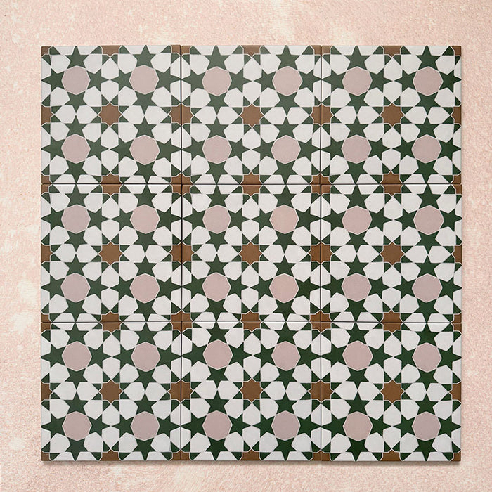 Conjunto de azulejos de estilo marroquí Agraba Tanane 20x20 cm mostrando un patrón geométrico repetido de estrellas y cruces en verde bosque, rosa empolvado, blanco y tonos tierra, con acabado mate suave.
