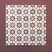 Primer plano de varios azulejos cerámicos de estilo marroquí Agraba Cotto 20x20 cm colocados en cuadrícula, mostrando un patrón geométrico de estrellas en terracota, beige, mostaza y blanco sobre fondo burdeos cálido.