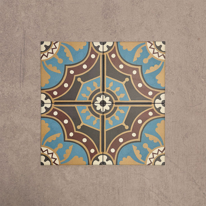 Cuatro baldosas Europa Hanover 20 × 20 cm de estilo Victoriano Marroquí colocadas juntas para mostrar el patrón decorativo repetitivo en tonos azul, terracota, mostaza y crema, sobre un fondo beige texturizado.