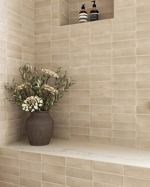 Baño con azulejos de pared Atlas Canvas Mini Brick 5x15 cm en acabado mate, instalados en disposición lineal, mostrando tonos neutros suaves con un acabado ligeramente texturizado, combinados con grifería en latón en un entorno contemporáneo y sereno.