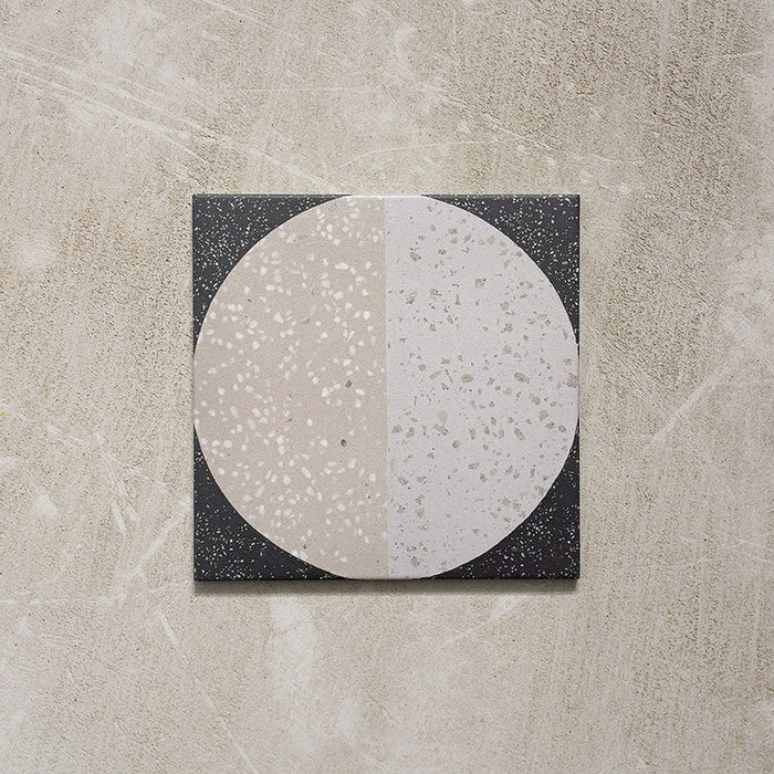 Kasuf Night 20x20cm terrazzo-style decor tiles featuring a bold monochrome circular pattern with speckled terrazzo detailing, ideal for creating statement floors and contemporary geometric interiors.