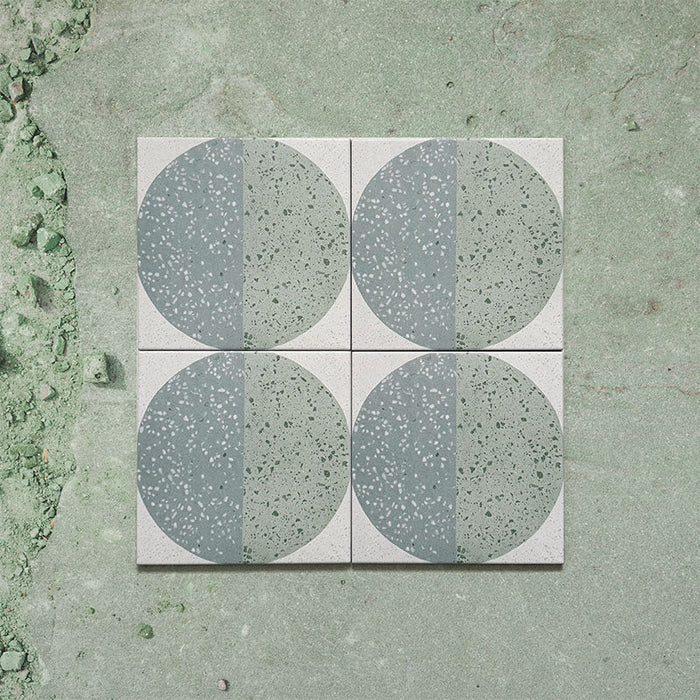 Kasuf Verde 20x20cm terrazzo-style decor tiles featuring a soft sage green and pale blue circular pattern with speckled terrazzo detailing, perfect for creating calming geometric floors and contemporary statement interiors.