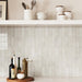 Cocina con azulejos de pared Atlas White Mini Brick 5x15 cm en acabado brillo, colocados en disposición horizontal tipo ladrillo para crear un fondo limpio y estructurado. Los tonos blancos suaves y la ligera variación tonal aportan profundidad, mientras que el acabado brillante refleja la luz sobre la superficie, aumentando la luminosidad en todo el espacio.