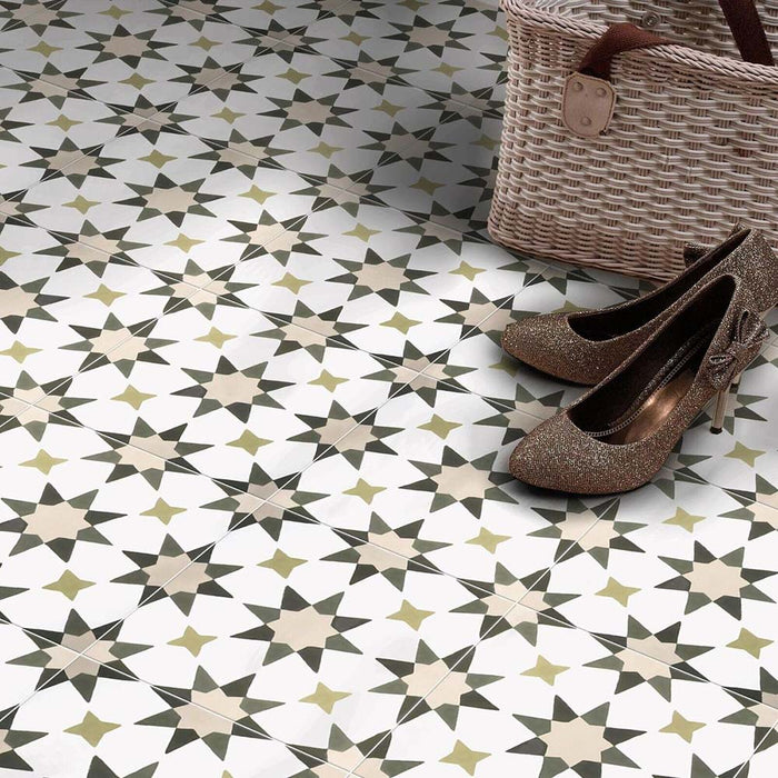 Azulejos de suelo de estilo marroquí Agraba Natural 20x20 cm con patrón geométrico de estrellas en tonos beige, topo y oliva, colocados en un recibidor con cesta de fibras naturales y zapatos brillantes para un ambiente cálido y neutro.