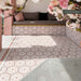 Zona de estar exterior con azulejos hexagonales Maroush Dusty Pink de 18,7 × 21,6 cm de estilo marroquí, instalados tanto en el suelo como en los asientos de obra, con un elaborado patrón geométrico en rosa y blanco y azulejos de borde a juego.