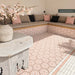Zona de estar exterior con azulejos hexagonales Maroush Dusty Pink de 18,7 × 21,6 cm de estilo marroquí, instalados tanto en el suelo como en los asientos de obra, con un elaborado patrón geométrico en rosa y blanco y azulejos de borde a juego.