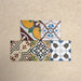 Fihrdos Mini Patchwork Moroccan-style 15x15cm patterned porcelain tiles arranged in a grouped layout, showcasing a mix of colourful geometric and traditional decorative designs.