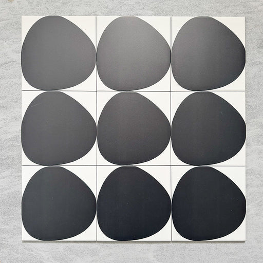 Pebble Beach Reversed Black 20x20cm patterned tiles featuring a bold black organic circular design, ideal for creating striking monochrome floors and statement walls with a contemporary geometric aesthetic.