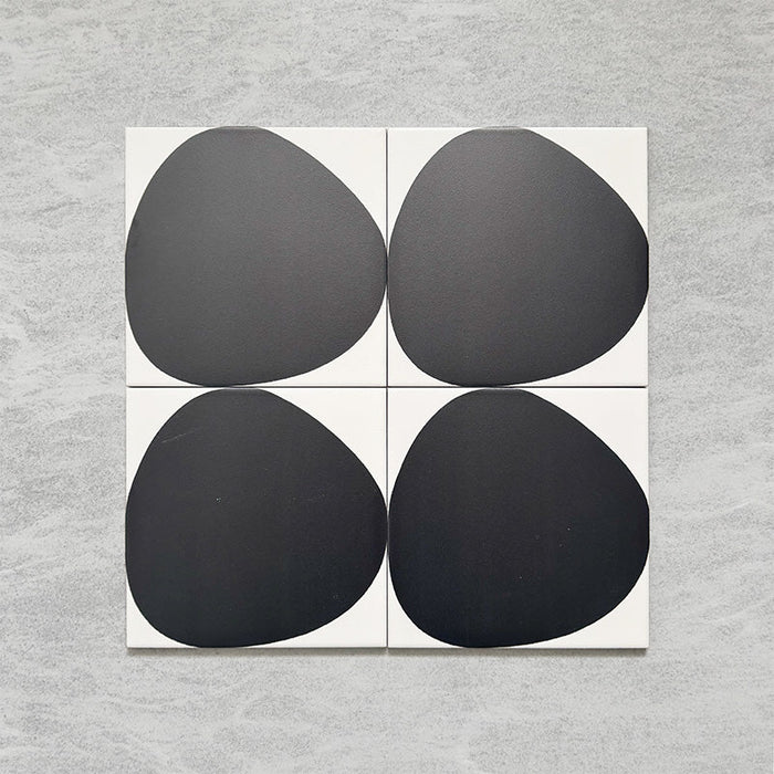 Pebble Beach Reversed Black 20x20cm patterned tiles featuring a bold black organic circular design, ideal for creating striking monochrome floors and statement walls with a contemporary geometric aesthetic.