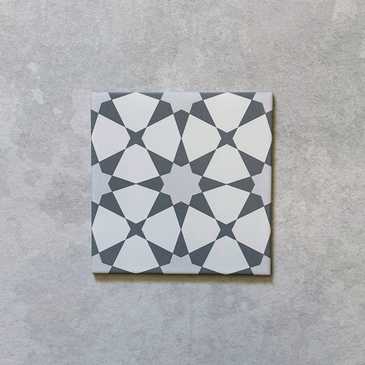 Imagen de producto del azulejo cerámico mate de estilo marroquí Agraba Plateado 20x20 cm, con patrón geométrico en tonos plateado y blanco inspirado en el diseño tradicional morisco, apto para pared y suelo, resistente a las heladas y con clasificación antideslizante R11.