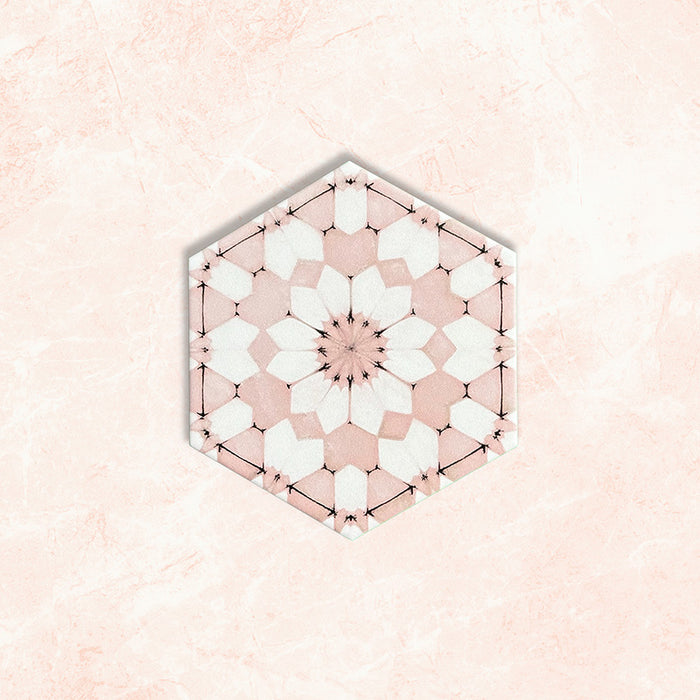 Baldosa hexagonal Maroush Rosa Empolvado 18,7x21,6 cm de estilo marroquí con diseño floral en forma de estrella en tonos rosa suave y blanco, presentada sobre un fondo efecto mármol claro.