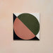Single tile image showing the Geometry Moon 20x20cm geometric patterned tile with green and terracotta semicircles and black and cream corner details, photographed against a soft peach-toned background.